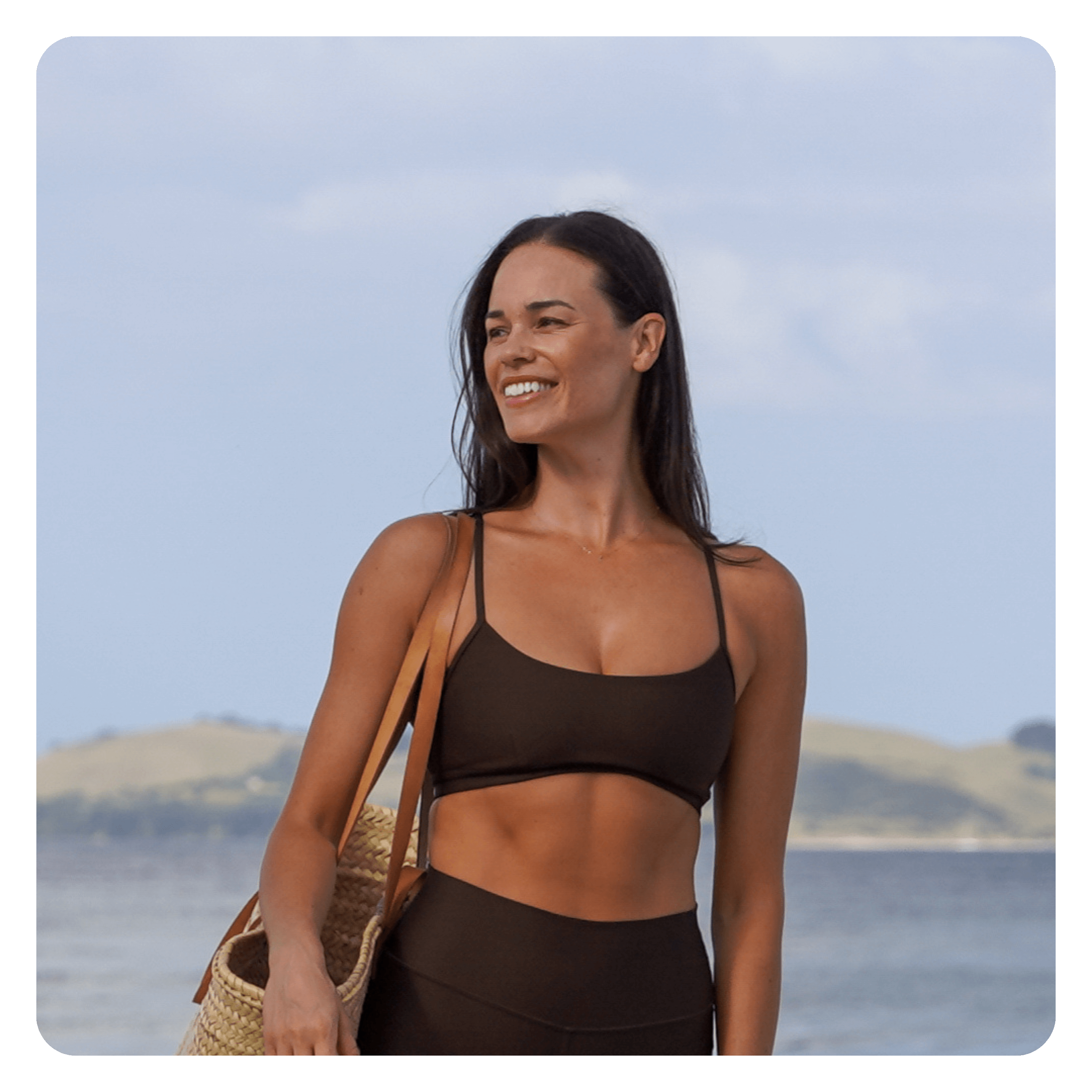 Laura standing on the beach in activewear.