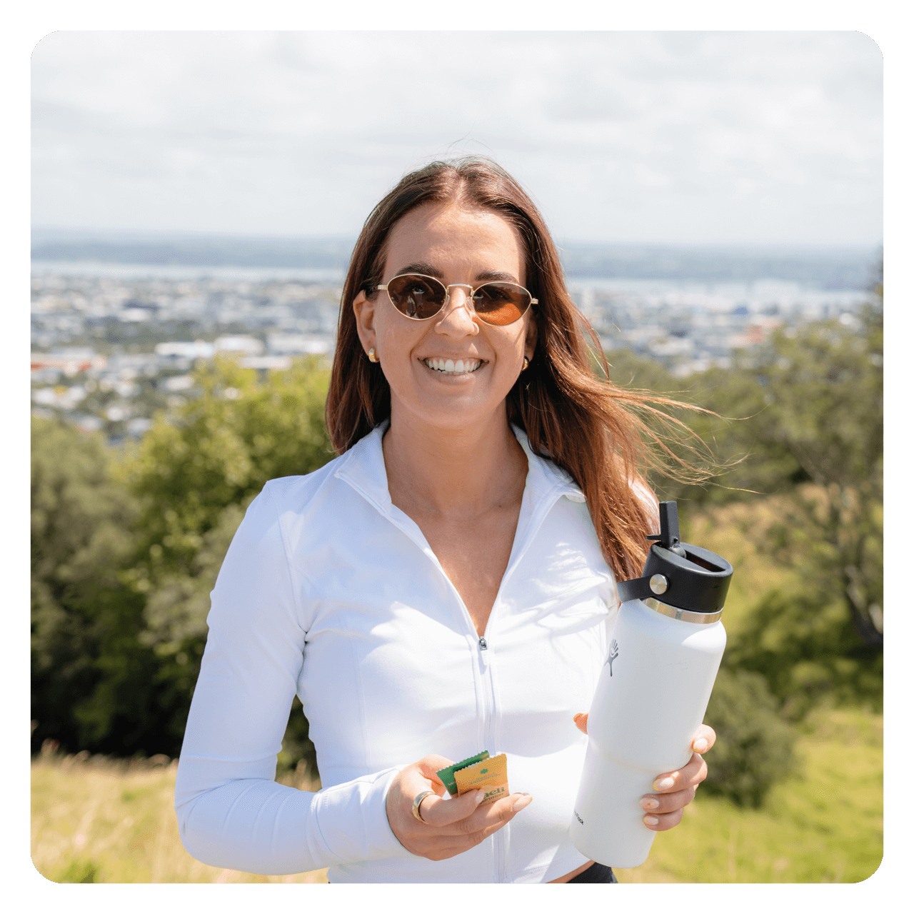 Sarah holding Daeli Hydration sachets and a drink bottle.