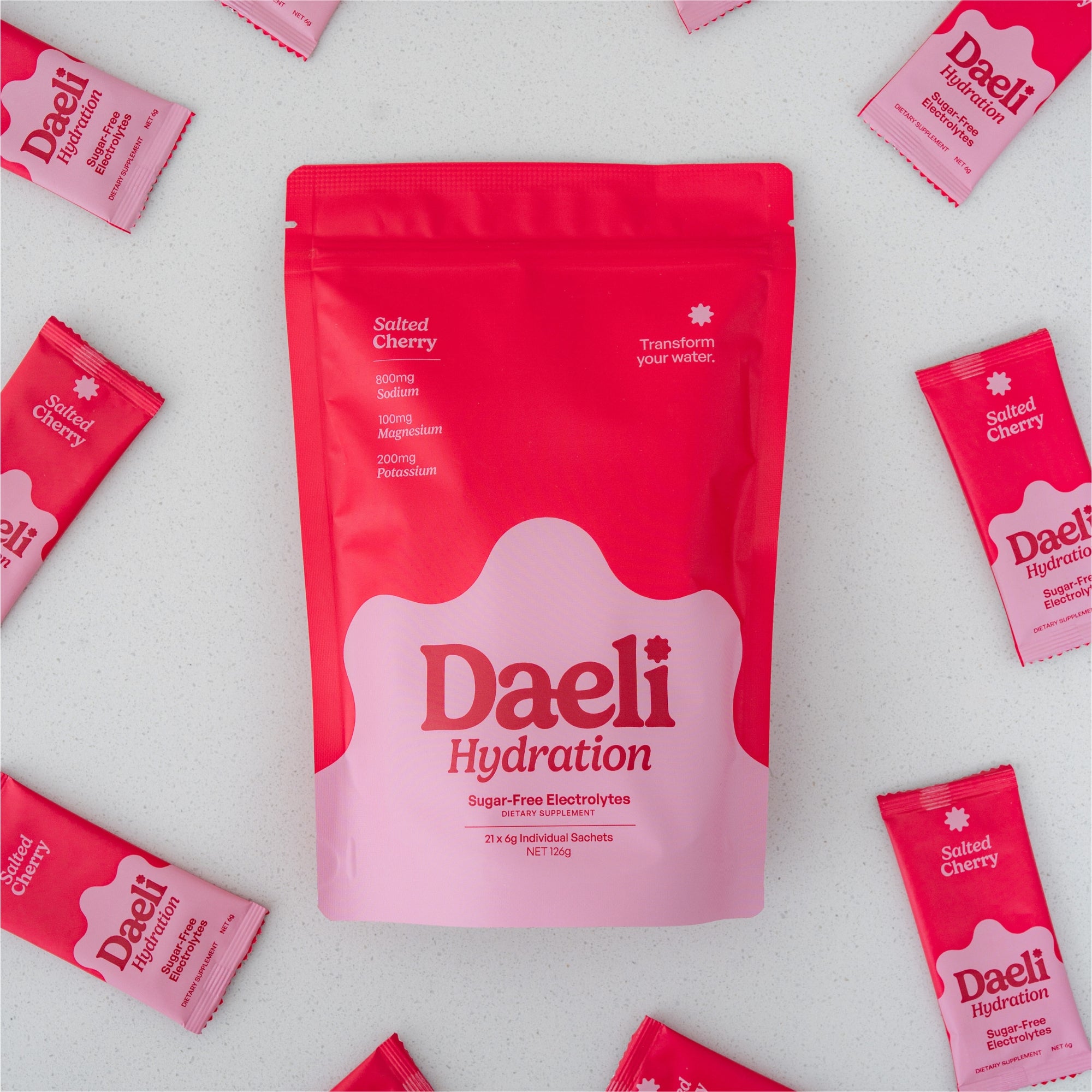 Daeli Hydration Salted Cherry electrolyte pouch surrounded by Daeli Salted Cherry sachets.